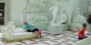 Turista sentado e reclinado sobre o a escultur. Museu Gypsotheca, Possagno, Itália.